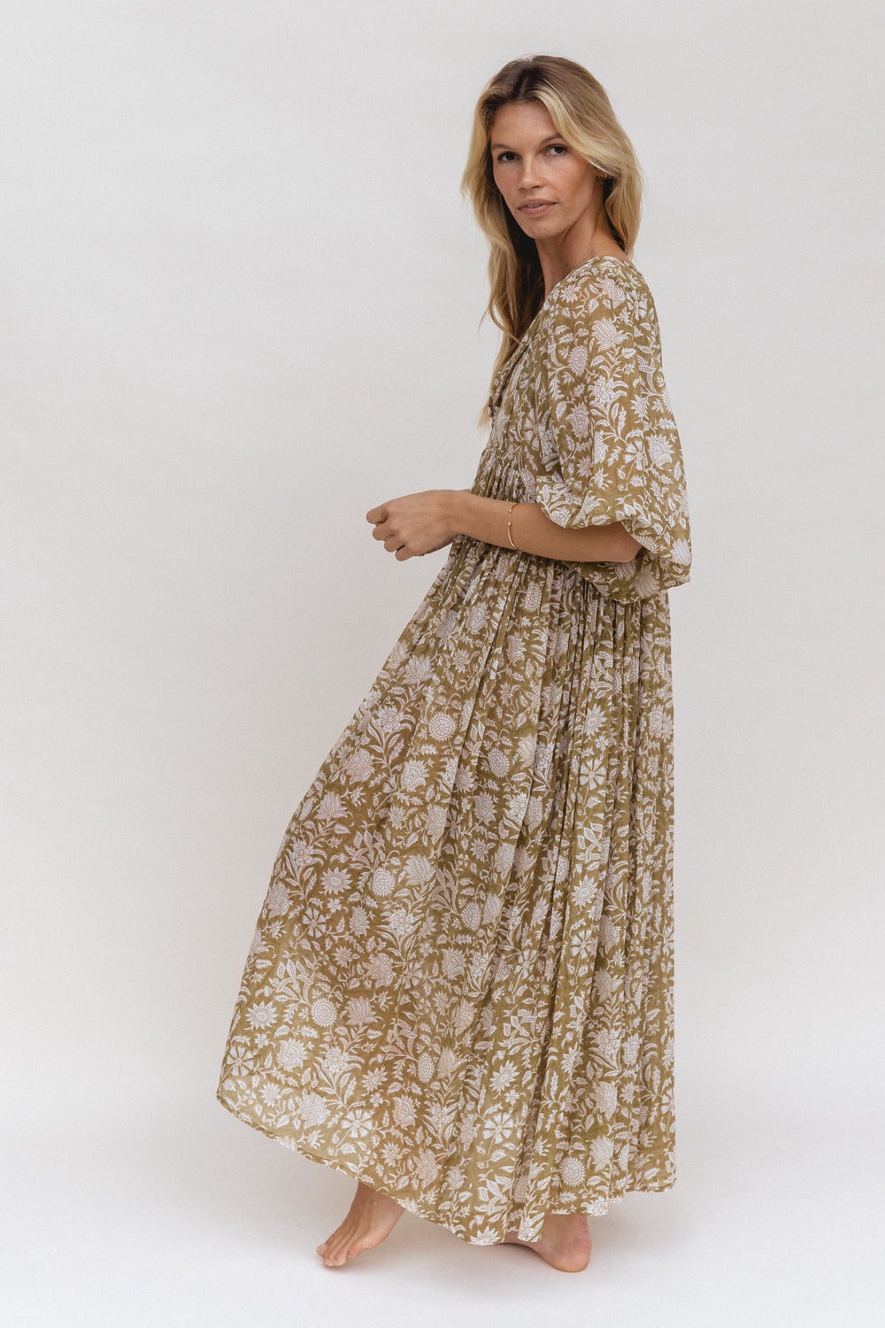 Daughters of India Kyra Maxi Dress in Olive — studio side profile walking, gathered waist and flowing skirt