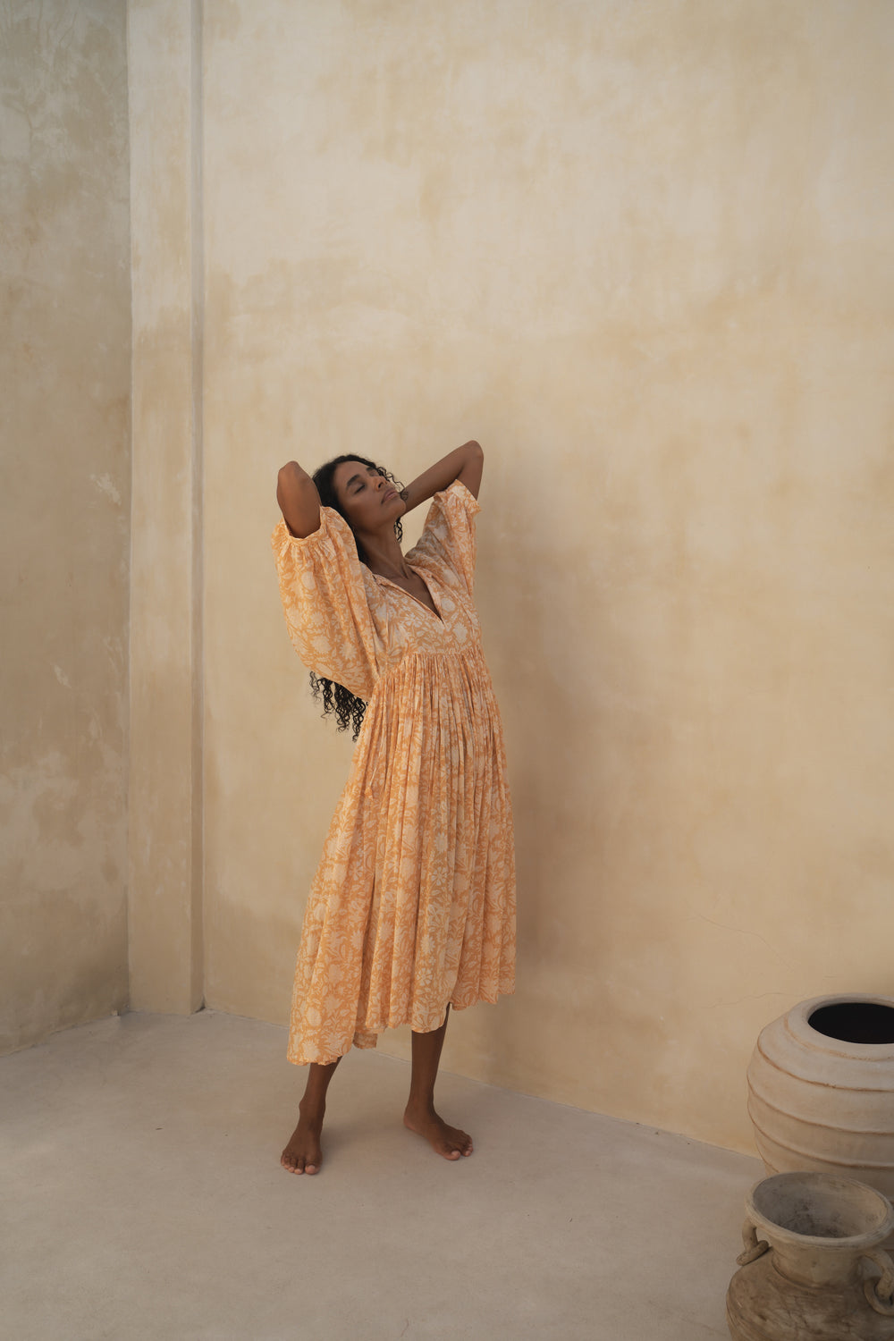 Daughters of India Kyra Midi Dress in Tangerine — standing by sand wall with clay pots, cotton